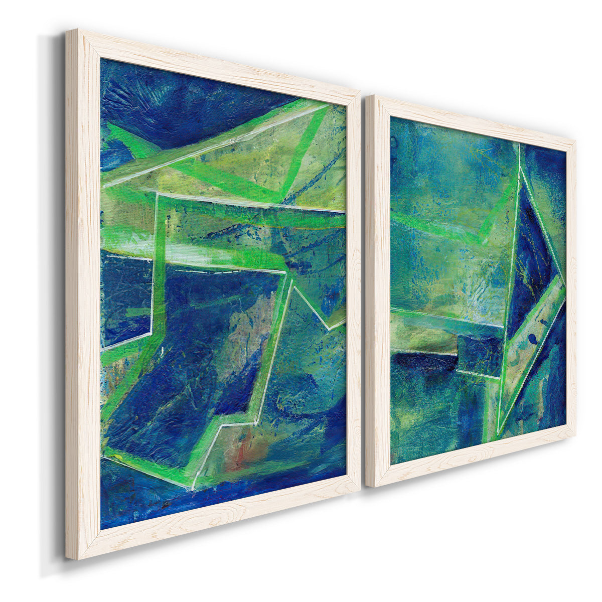 Angled view of a set of two white barnwood framed canvas prints featuring two textured geometric abstracts featuring interlocking blue and green angular forms.