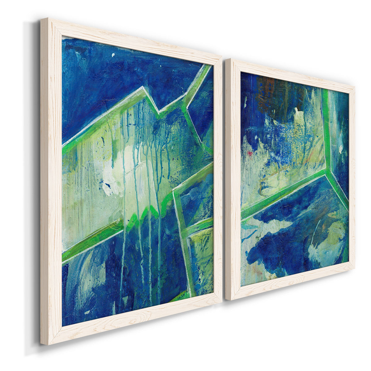 Angled view of a set of two white barnwood framed canvas prints featuring two textured geometric abstracts featuring interlocking blue and green angular forms.