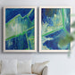 Set of two white barnwood framed canvas prints depicting deep cobalt fields, bright green edges, and layered linear facets arranged across two complementary compositions above a sofa in a bright living space.