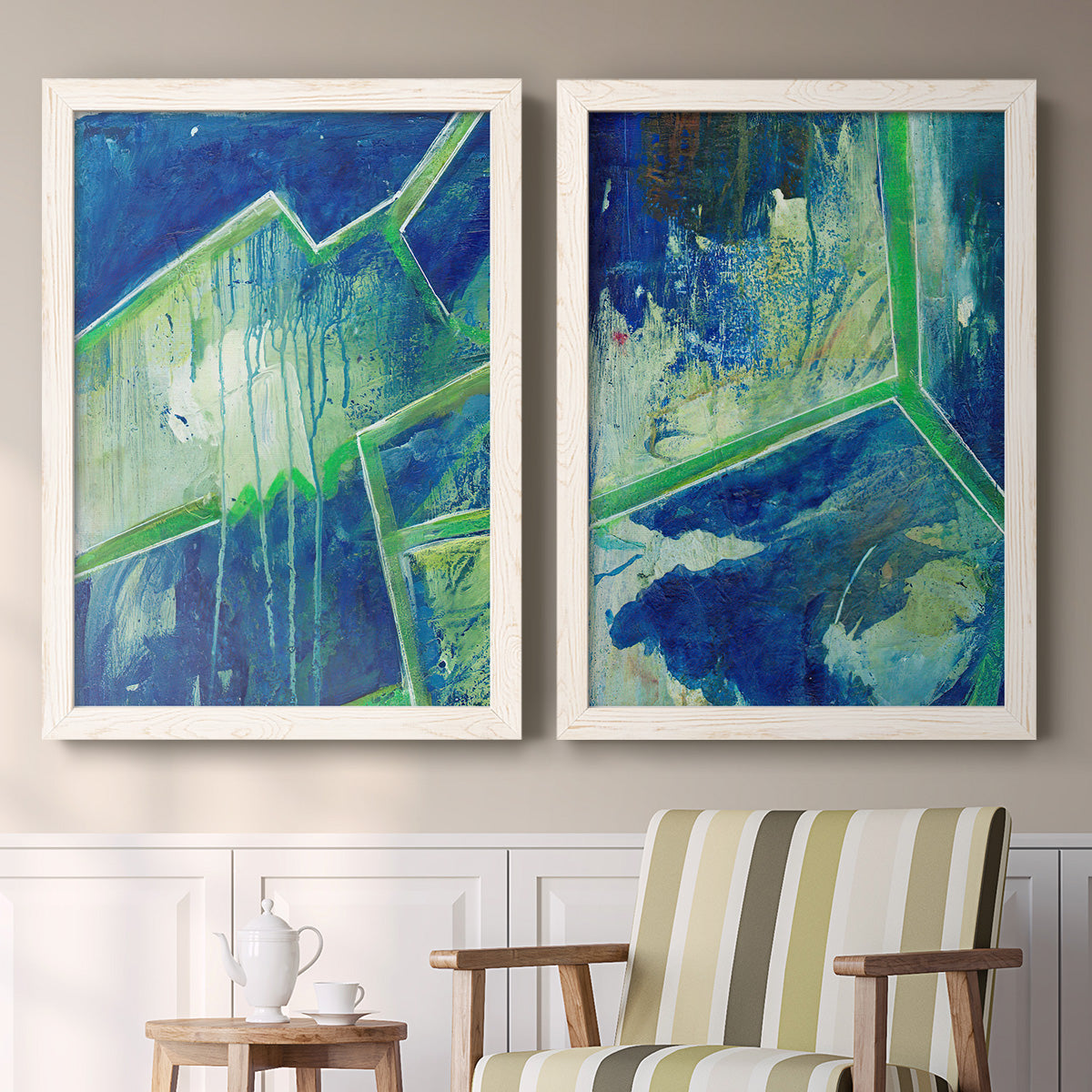 Set of two white barnwood framed canvas prints depicting two textured geometric abstracts featuring interlocking blue and green angular forms above a sideboard in a cozy sitting room.