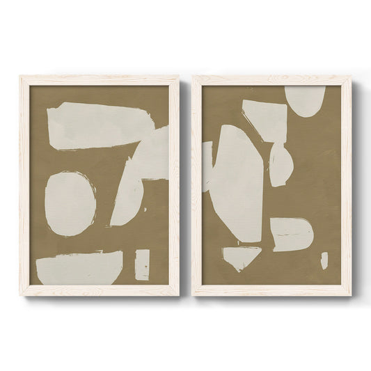 Set of two white barnwood framed canvas prints featuring two bold minimalist shape abstracts featuring irregular white cutout-like shapes on taupe grounds.