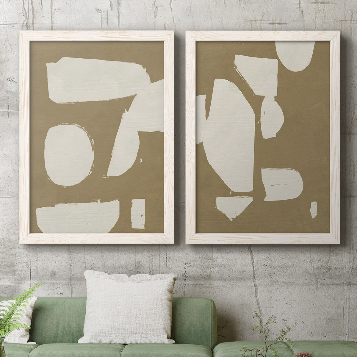 Set of two white barnwood framed canvas prints depicting a coordinated art pair of irregular white cutout-like shapes on taupe grounds rendered as bold minimalist shape abstracts above a sofa in a modern living room.