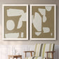 Set of two white barnwood framed canvas prints depicting two bold minimalist shape abstracts featuring irregular white cutout-like shapes on taupe grounds above a sideboard in a cozy sitting room.