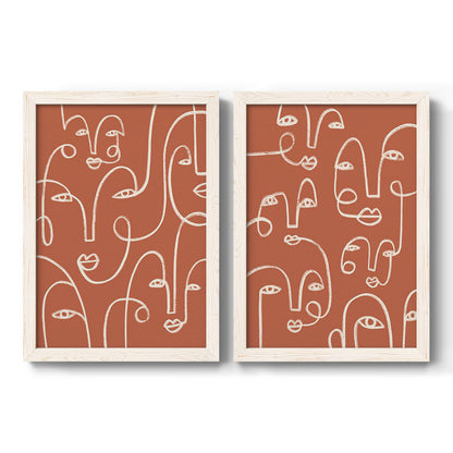 Set of two white barnwood framed canvas prints featuring two graphic portrait patterns featuring many continuous-line faces across terracotta grounds.