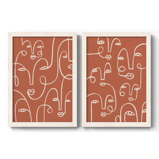 Set of two white barnwood framed canvas prints featuring two graphic portrait patterns featuring many continuous-line faces across terracotta grounds.