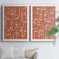 Set of two white barnwood framed canvas prints depicting white outlined features, repeated profiles, and playful clustered expressions arranged across two complementary compositions above a sofa in a bright living space.