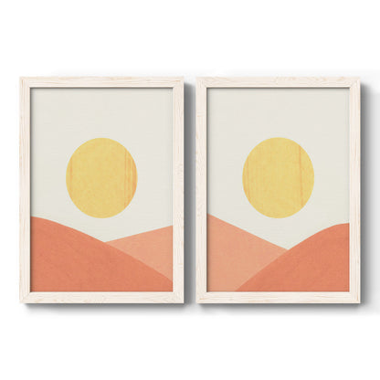 Set of two white barnwood framed canvas prints featuring two minimalist boho landscapes featuring yellow suns rising over terracotta geometric hills.