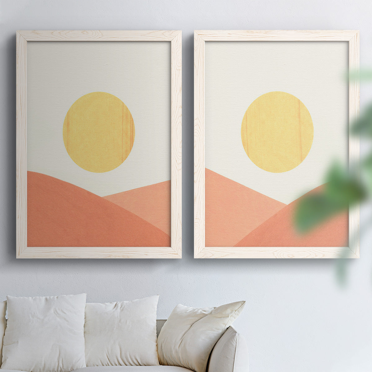 Set of two white barnwood framed canvas prints depicting flat semicircles, warm peach slopes, and clean cream skies arranged across two complementary compositions above a sofa in a bright living space.