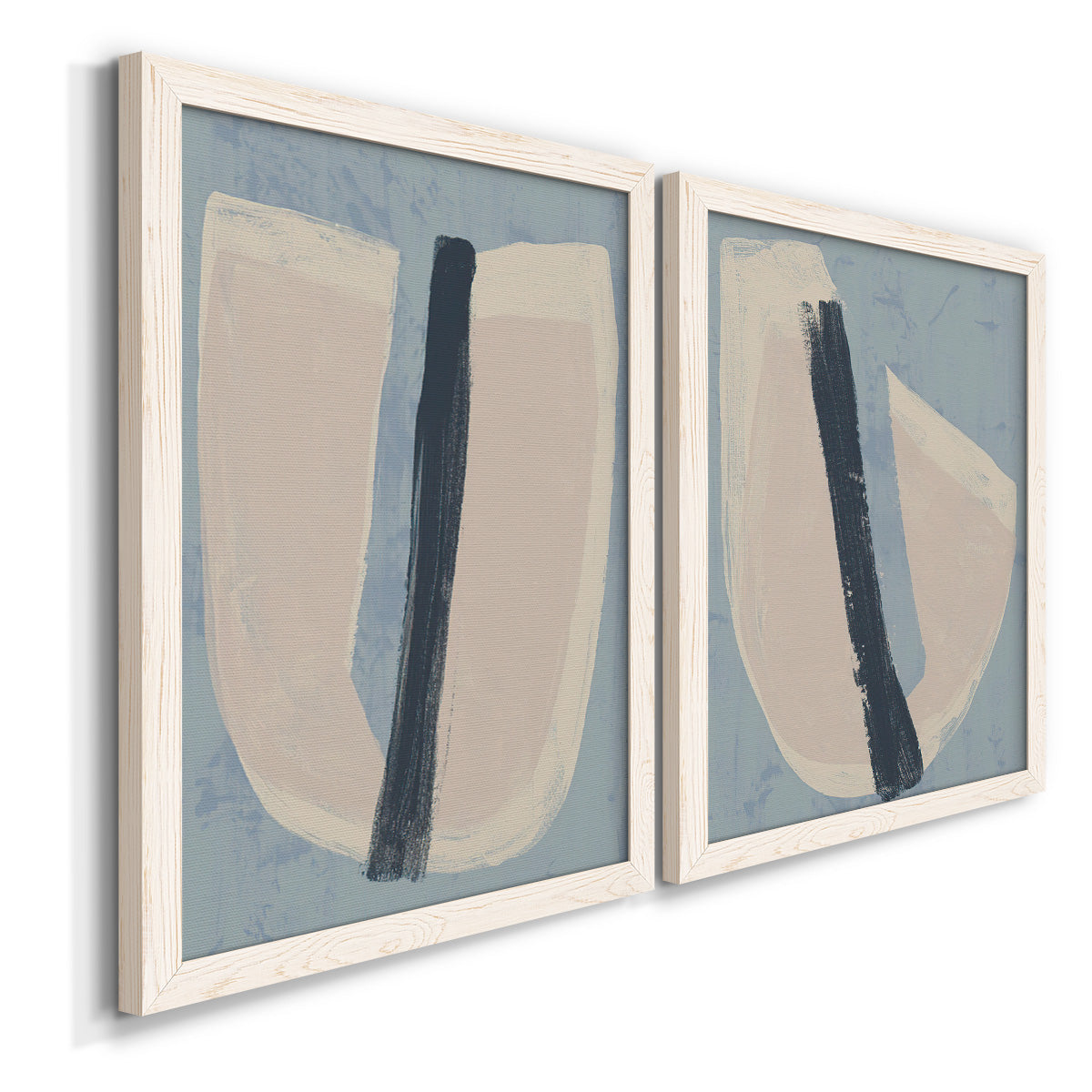 Angled view of a set of two white barnwood framed canvas prints featuring two minimalist collage-style abstracts featuring single navy brush slashes across layered paper-like shapes.