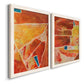 Angled view of a set of two white barnwood framed canvas prints featuring two warm geometric abstracts featuring faceted rust orange and coral geometric fields.
