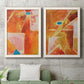 Set of two white barnwood framed canvas prints depicting a coordinated art pair of faceted rust orange and coral geometric fields rendered as warm geometric abstracts above a sofa in a modern living room.
