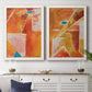 Set of two white barnwood framed canvas prints depicting a coordinated art pair of faceted rust orange and coral geometric fields rendered as warm geometric abstracts above a dining room sideboard.