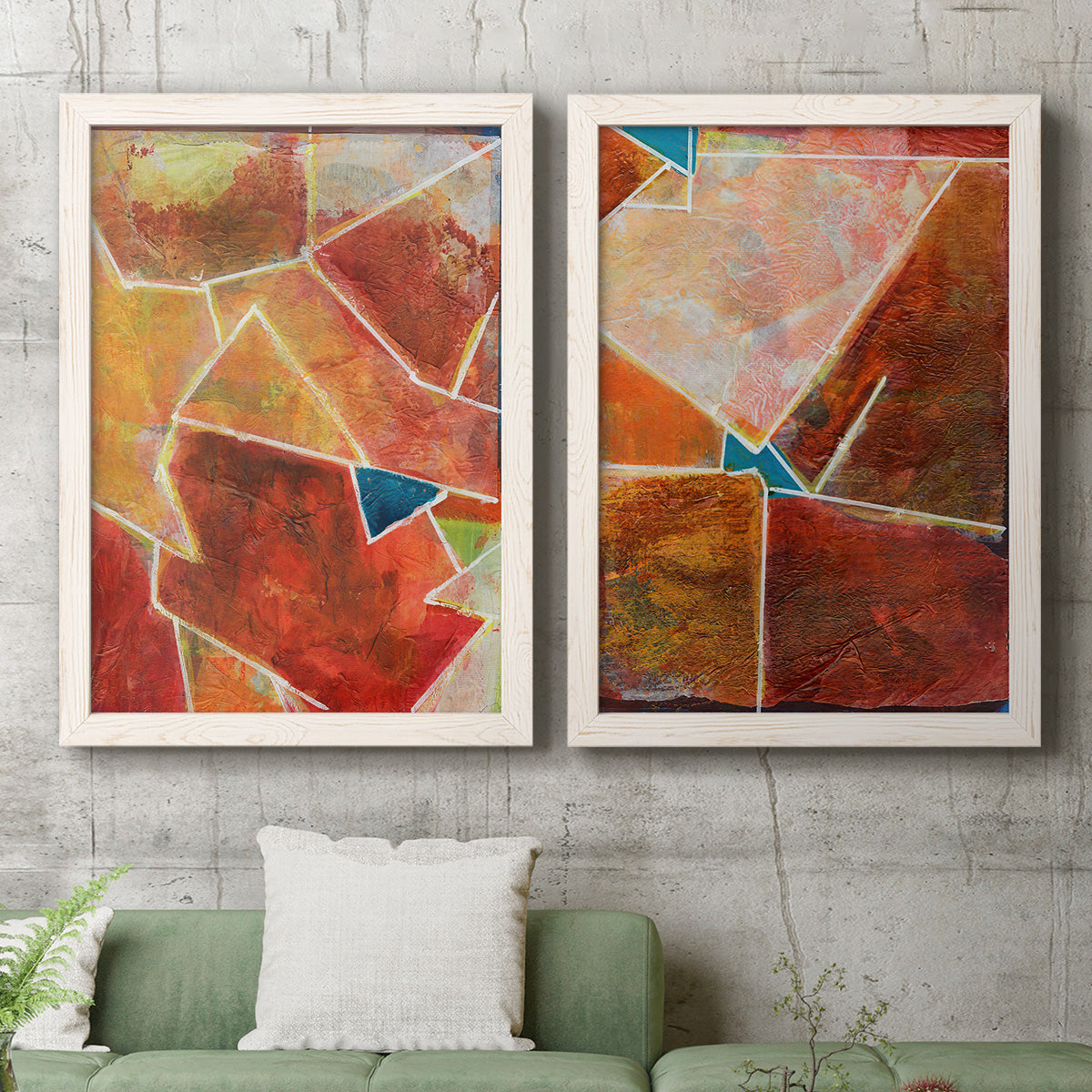 Set of two white barnwood framed canvas prints depicting a coordinated art pair of faceted rust orange and coral geometric fields rendered as warm geometric abstracts above a sofa in a modern living room.