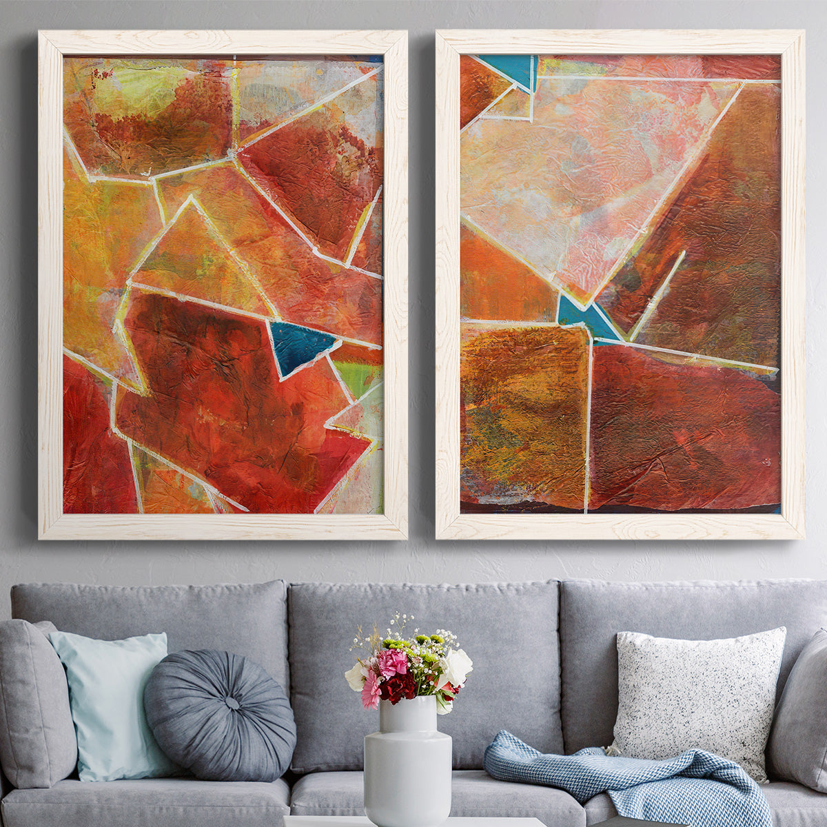 Set of two white barnwood framed canvas prints depicting paired warm geometric abstracts with white dividing lines, small turquoise accents, and layered painted texture above a sofa in a contemporary living room.