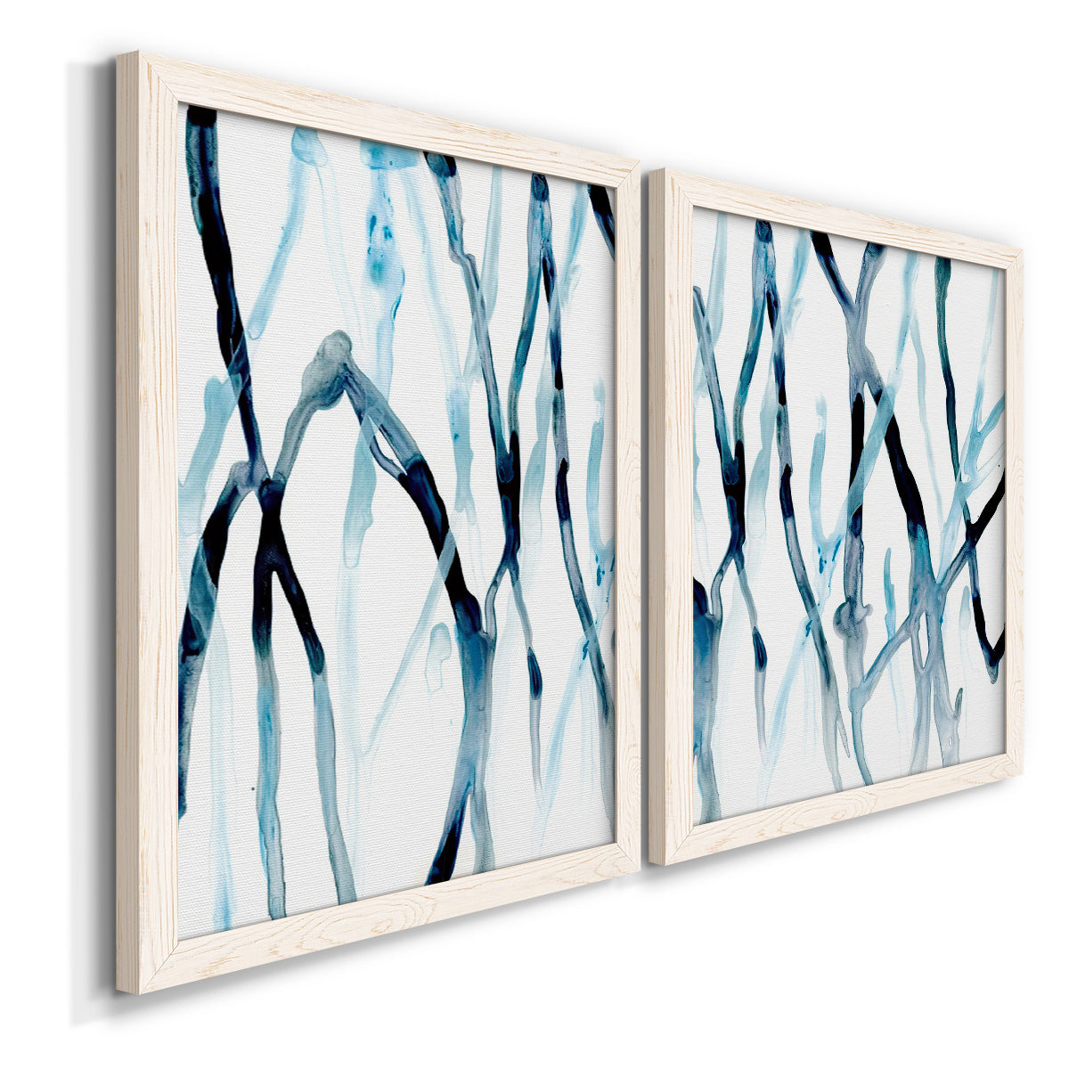 Angled view of a set of two white barnwood framed canvas prints featuring two fluid organic abstracts featuring branching watercolor lines drifting across white.