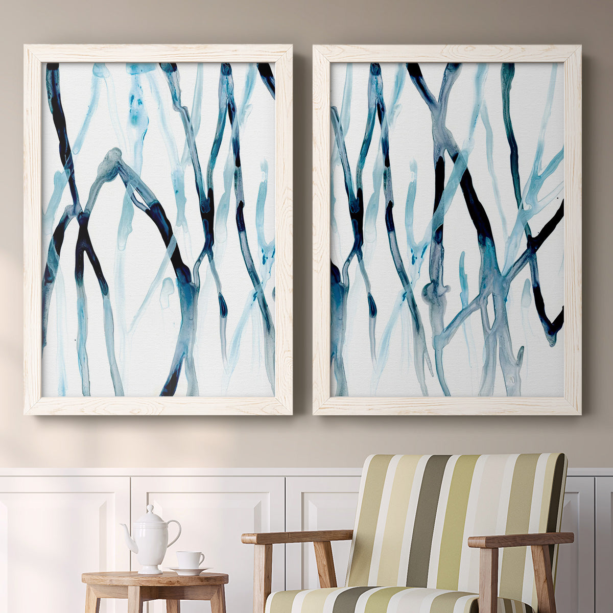 Set of two white barnwood framed canvas prints depicting two fluid organic abstracts featuring branching watercolor lines drifting across white above a sideboard in a cozy sitting room.