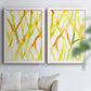 Set of two white barnwood framed canvas prints depicting slender vein-like strokes, transparent overlaps, and open negative space arranged across two complementary compositions above a sofa in a bright living space.