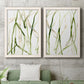 Set of two white barnwood framed canvas prints depicting a coordinated art pair of branching watercolor lines drifting across white rendered as fluid organic abstracts above a sofa in a modern living room.