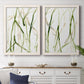 Set of two white barnwood framed canvas prints depicting a coordinated art pair of branching watercolor lines drifting across white rendered as fluid organic abstracts above a dining room sideboard.