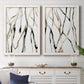 Set of two white barnwood framed canvas prints depicting a coordinated art pair of branching watercolor lines drifting across white rendered as fluid organic abstracts above a dining room sideboard.