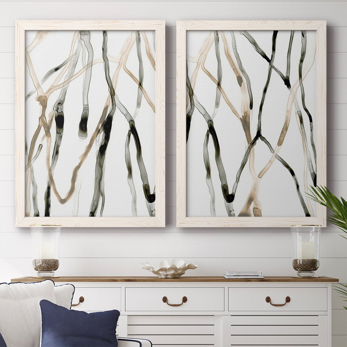 Set of two white barnwood framed canvas prints depicting a coordinated art pair of branching watercolor lines drifting across white rendered as fluid organic abstracts above a dining room sideboard.