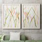 Set of two white barnwood framed canvas prints depicting a coordinated art pair of branching watercolor lines drifting across white rendered as fluid organic abstracts above a sofa in a modern living room.