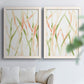 Set of two white barnwood framed canvas prints depicting slender vein-like strokes, transparent overlaps, and open negative space arranged across two complementary compositions above a sofa in a bright living space.