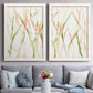 Set of two white barnwood framed canvas prints depicting paired fluid organic abstracts with slender vein-like strokes, transparent overlaps, and open negative space above a sofa in a contemporary living room.