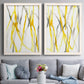 Set of two white barnwood framed canvas prints depicting paired fluid organic abstracts with slender vein-like strokes, transparent overlaps, and open negative space above a sofa in a contemporary living room.