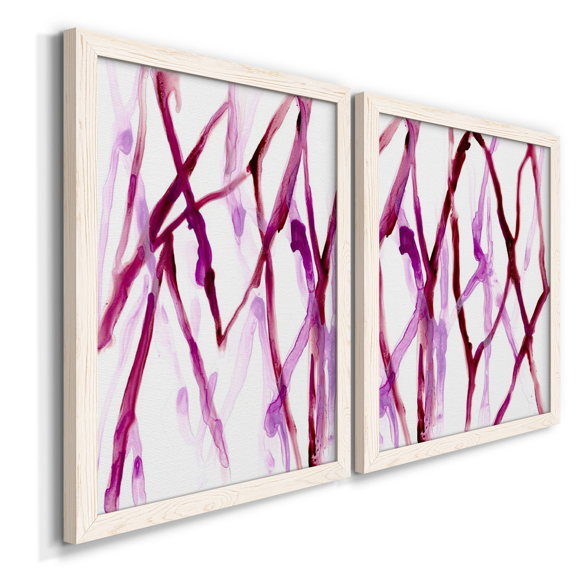 Angled view of a set of two white barnwood framed canvas prints featuring two fluid organic abstracts featuring branching watercolor lines drifting across white.