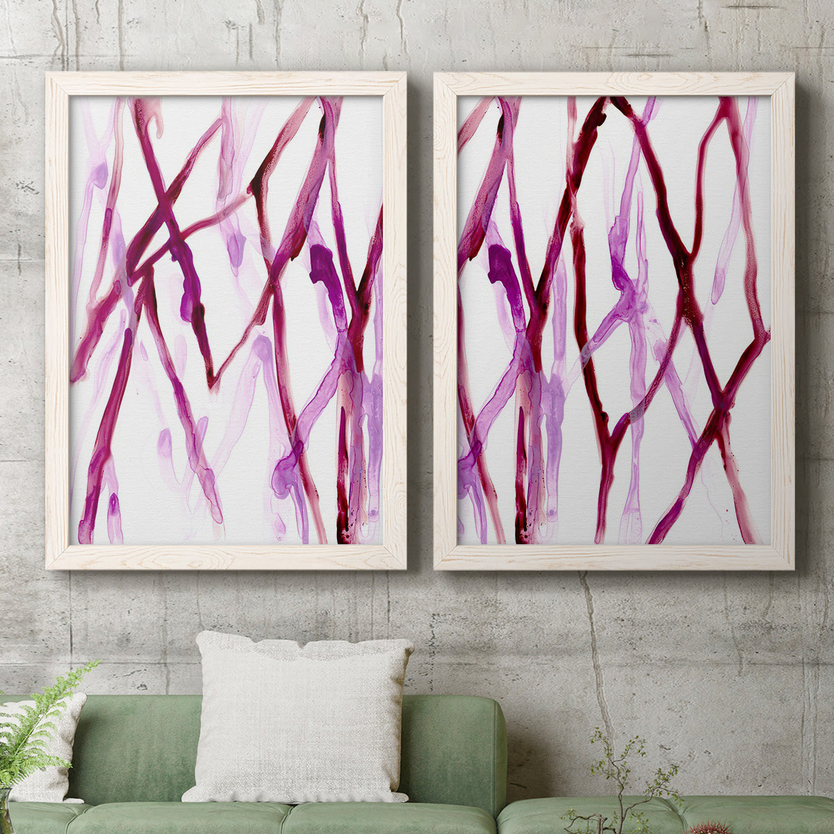 Set of two white barnwood framed canvas prints depicting a coordinated art pair of branching watercolor lines drifting across white rendered as fluid organic abstracts above a sofa in a modern living room.