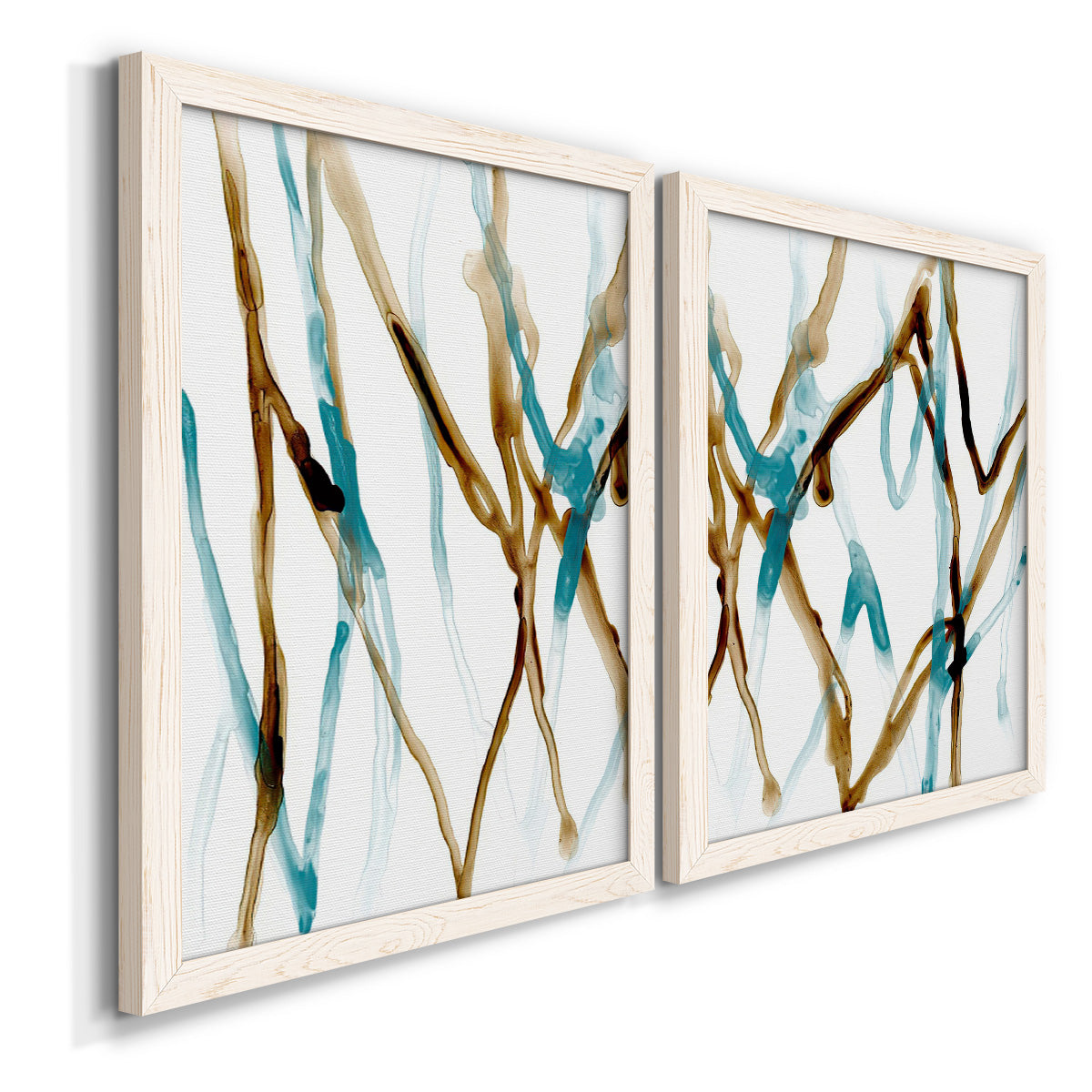 Angled view of a set of two white barnwood framed canvas prints featuring two fluid abstracts with branching turquoise and brown lines drifting across white backgrounds.