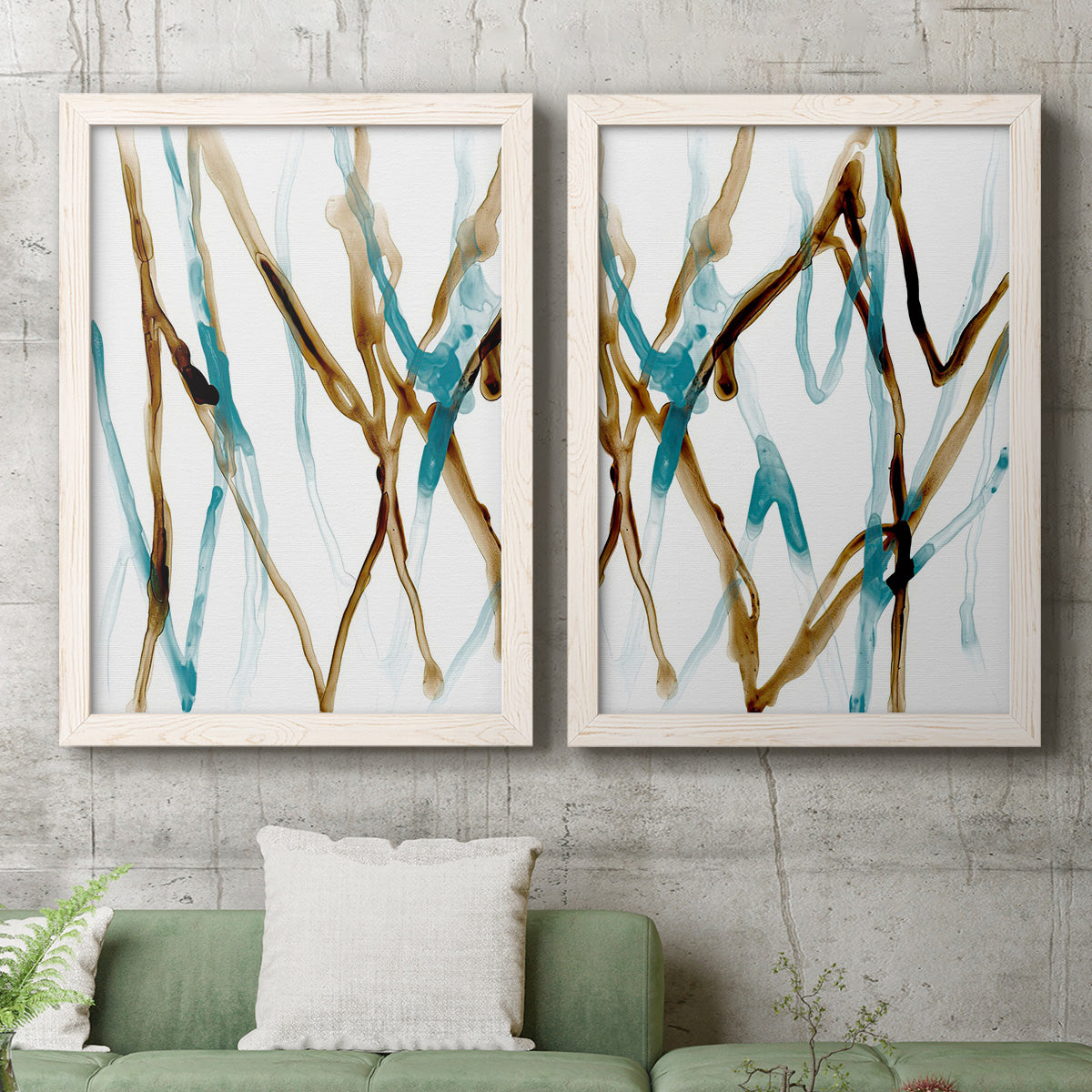 Set of two white barnwood framed canvas prints depicting a watercolor pair of elongated blue and umber trails with transparent overlapping edges above a sofa in a modern living room.