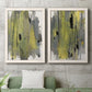 Set of two white barnwood framed canvas prints depicting a coordinated art pair of vertical abstract brush bands in changing muted palettes rendered as urban mixed-media abstracts above a sofa in a modern living room.
