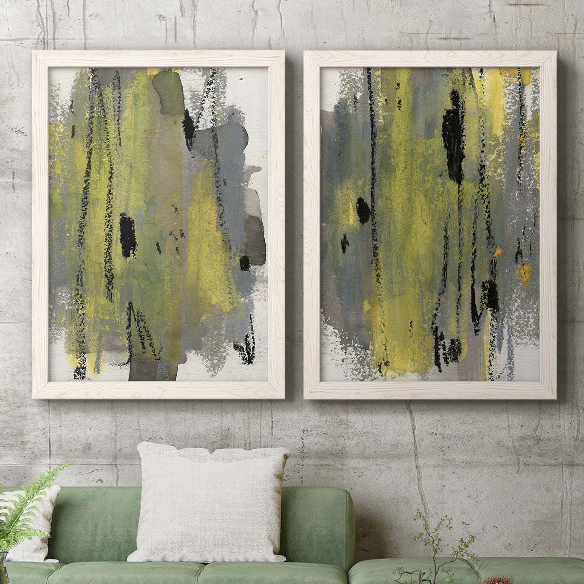 Set of two white barnwood framed canvas prints depicting a coordinated art pair of vertical abstract brush bands in changing muted palettes rendered as urban mixed-media abstracts above a sofa in a modern living room.