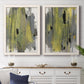 Set of two white barnwood framed canvas prints depicting a coordinated art pair of vertical abstract brush bands in changing muted palettes rendered as urban mixed-media abstracts above a dining room sideboard.
