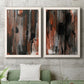 Set of two white barnwood framed canvas prints depicting a coordinated art pair of vertical abstract brush bands in changing muted palettes rendered as urban mixed-media abstracts above a sofa in a modern living room.