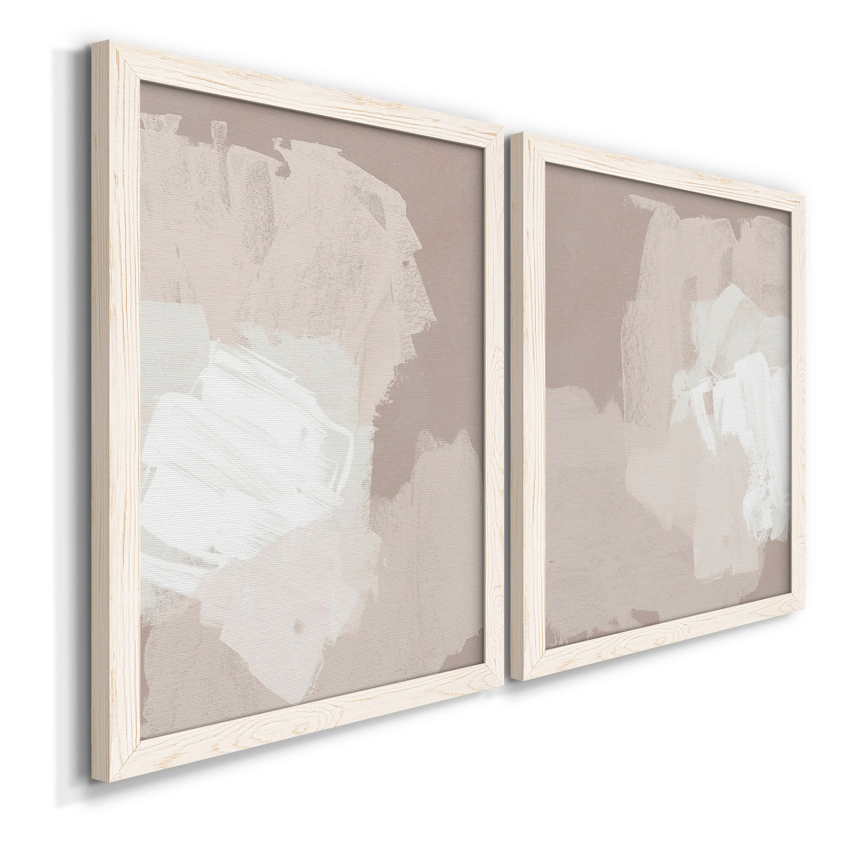 Angled view of a set of two white barnwood framed canvas prints featuring two neutral minimalist abstracts featuring soft taupe blush and white paint blocks.