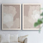 Set of two white barnwood framed canvas prints depicting broad rectangular strokes, cloudy overlaps, and subtle texture arranged across two complementary compositions above a sofa in a bright living space.
