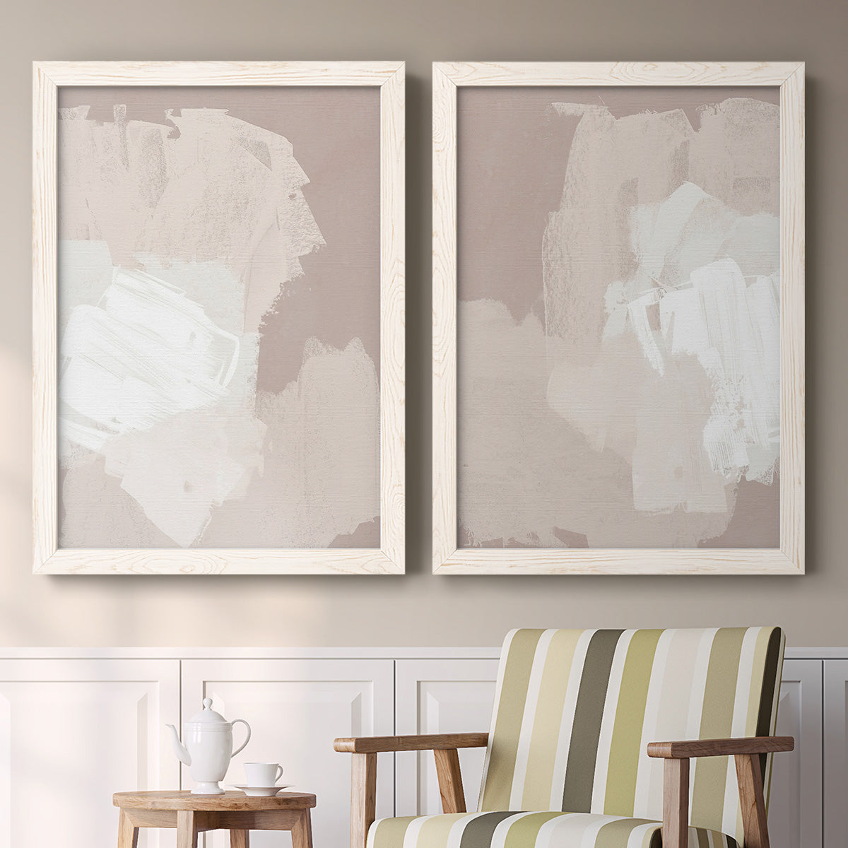 Set of two white barnwood framed canvas prints depicting two neutral minimalist abstracts featuring soft taupe blush and white paint blocks above a sideboard in a cozy sitting room.