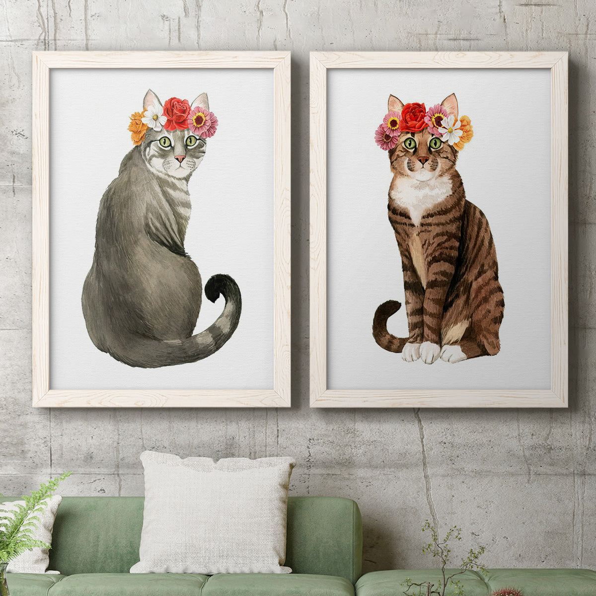 Set of two white barnwood framed canvas prints depicting a coordinated art pair of seated cats wearing colorful flower crowns rendered as whimsical animal portraits above a sofa in a modern living room.