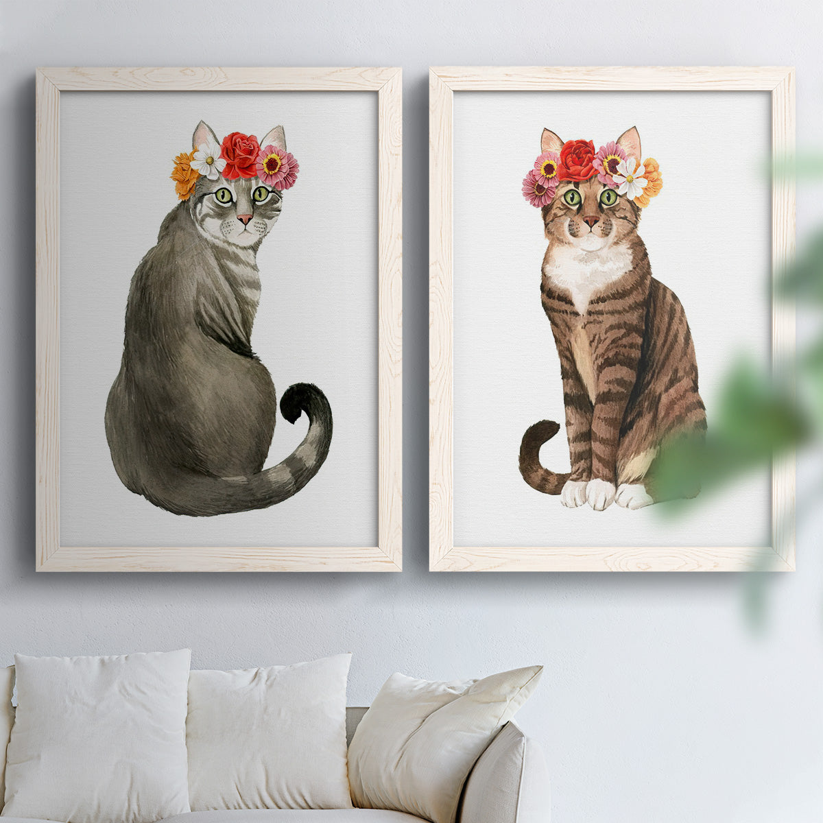 Set of two white barnwood framed canvas prints depicting tabby fur, pink orange and yellow blossoms, and clean white grounds arranged across two complementary compositions above a sofa in a bright living space.