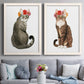 Set of two white barnwood framed canvas prints depicting paired whimsical animal portraits with tabby fur, pink orange and yellow blossoms, and clean white grounds above a sofa in a contemporary living room.