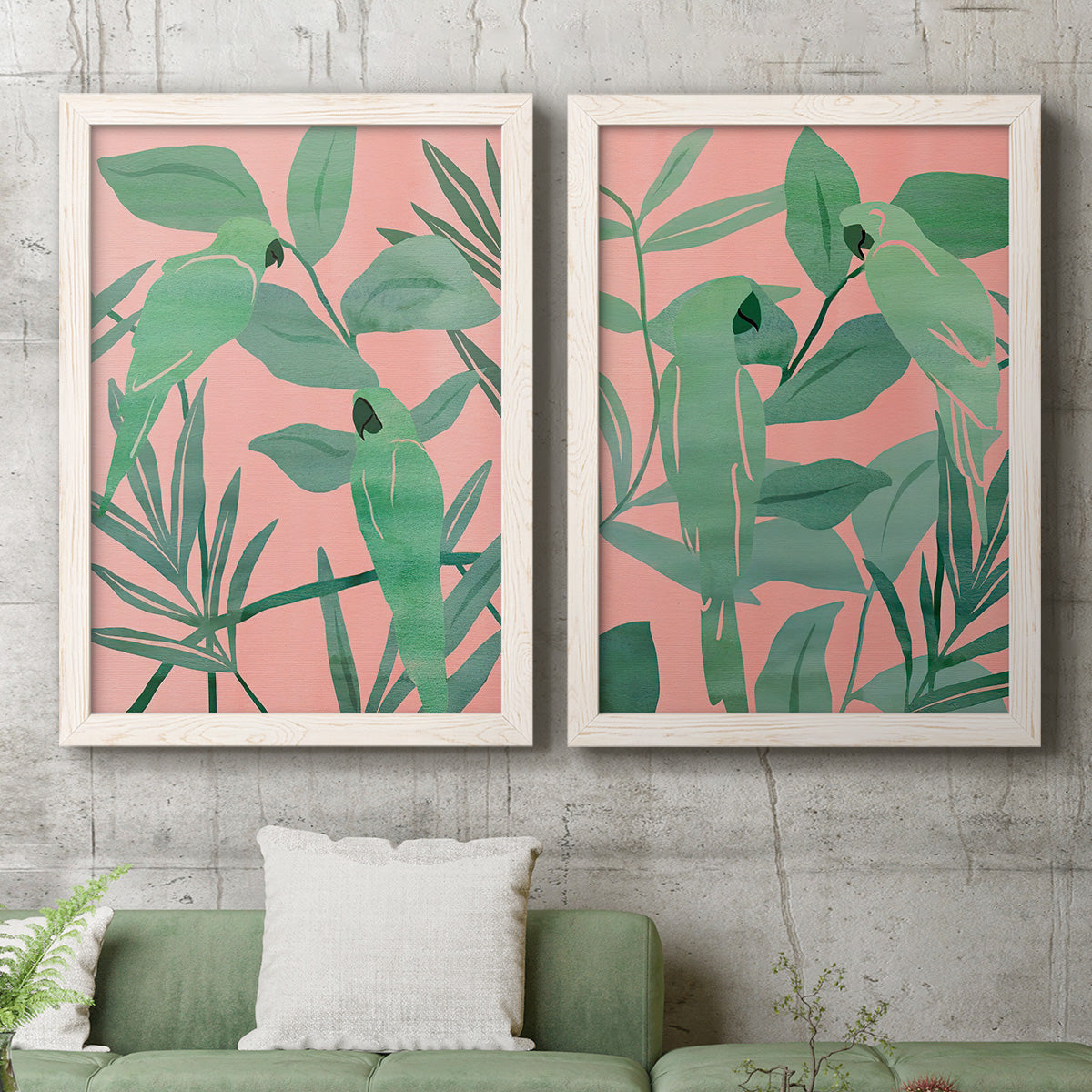 Set of two white barnwood framed canvas prints depicting a coordinated art pair of large green tropical leaves on coral-pink grounds rendered as bold tropical botanical prints above a sofa in a modern living room.