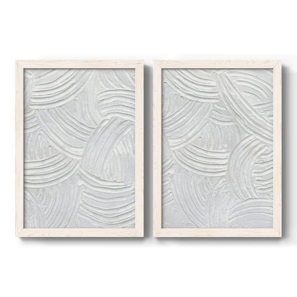 Set of two white barnwood framed canvas prints featuring two textural monochrome abstracts featuring overlapping white carved arcs and ridges.