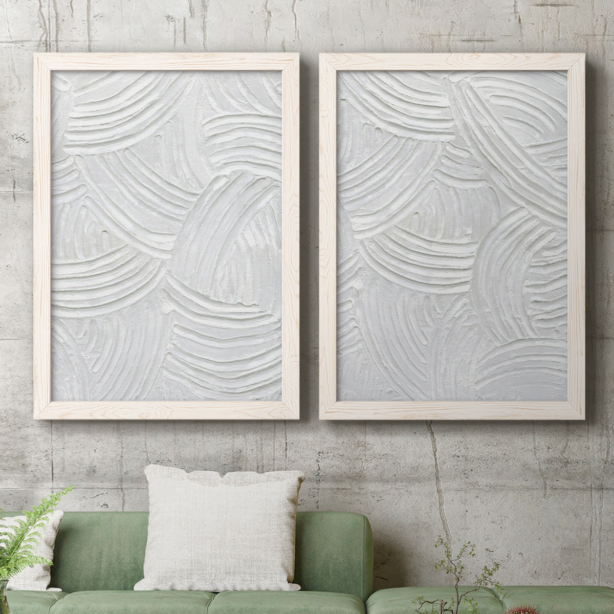 Set of two white barnwood framed canvas prints depicting a coordinated art pair of overlapping white carved arcs and ridges rendered as textural monochrome abstracts above a sofa in a modern living room.