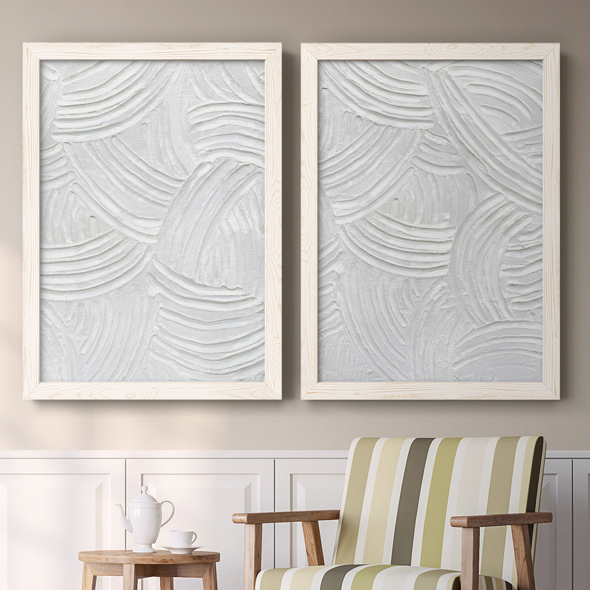 Set of two white barnwood framed canvas prints depicting two textural monochrome abstracts featuring overlapping white carved arcs and ridges above a sideboard in a cozy sitting room.
