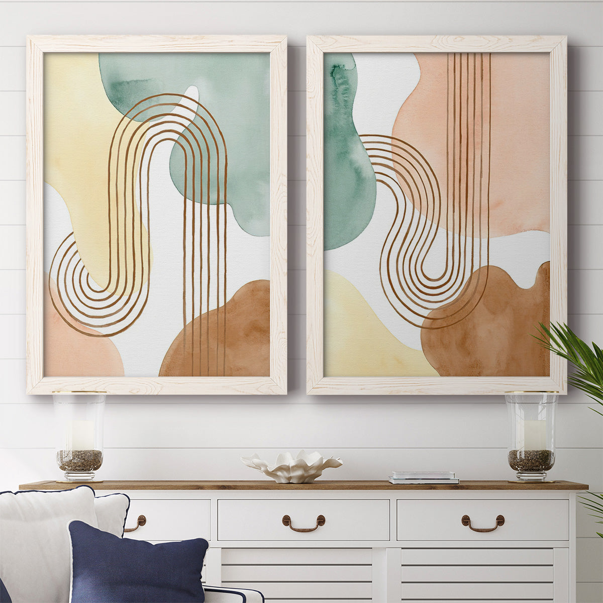 Set of two white barnwood framed canvas prints depicting a coordinated art pair of repeating indigo floral and leaf motifs rendered as folk-inspired botanical patterns above a dining room sideboard.