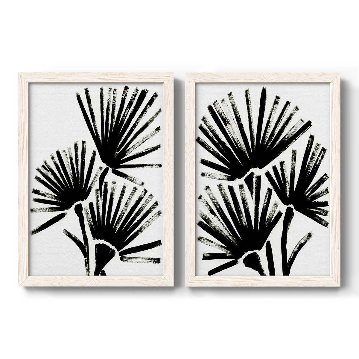 Set of two white barnwood framed canvas prints featuring two bold monochrome botanical prints featuring black fan-shaped botanical forms.