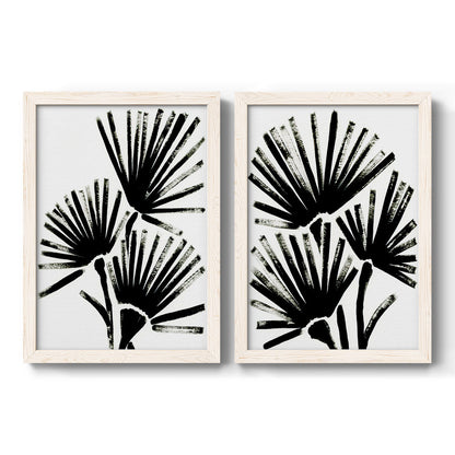 Set of two white barnwood framed canvas prints featuring two bold monochrome botanical prints featuring black fan-shaped botanical forms.